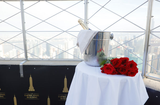 Roses and a bottle of champagne in an ice bucket on a table at the top of the Empire State Building